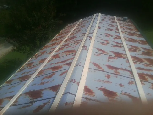 Rusted metal roof panels with new wood purlins before replacement — Storm Damage Roof Repair in Slickville by Roofing Brothers
