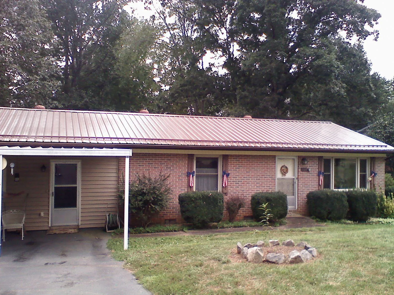 Bronze metal roof and carport on a brick ranch home — Roof Repair work by our crew in Slickville